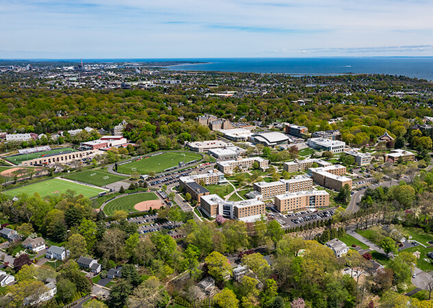 Bird's-eye view of the Fairfield University campus and adjacent environment, illustrating the layout and greenery of the location.