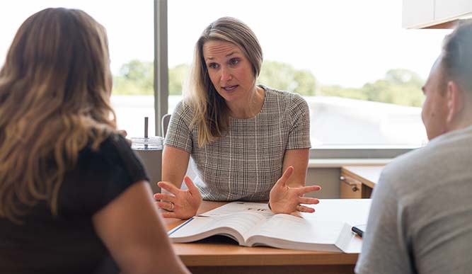 Image of teacher and students sitting in office