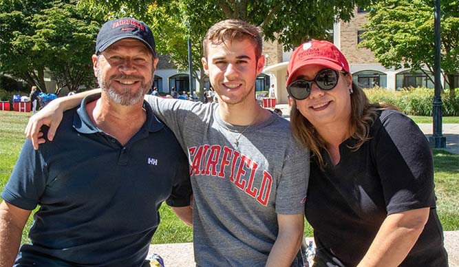 First-year student posing and smiling with his family during move-in weekend.