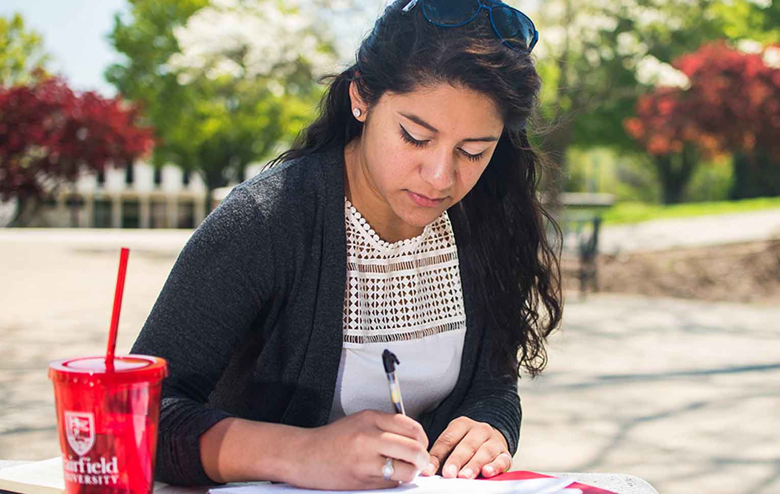 Women outside writing on paper.