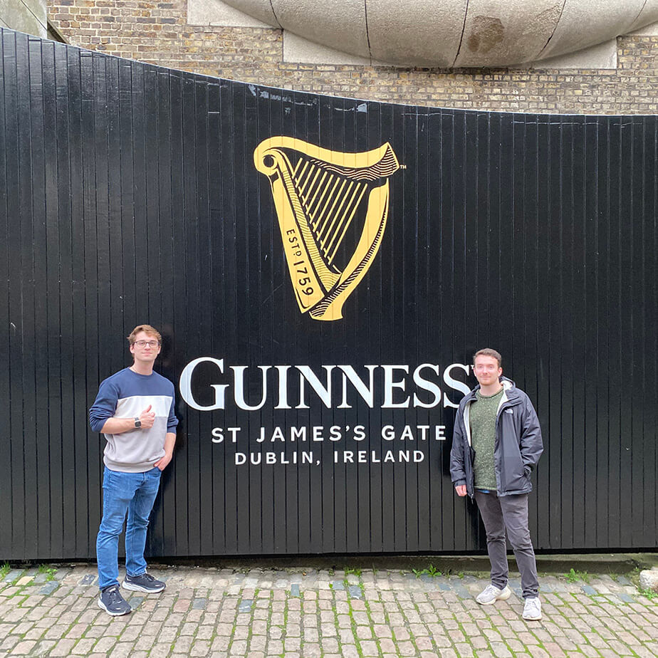 Two Fairfield students posing in front of the Guinness St. James's Gate sign in Dublin, Ireland.