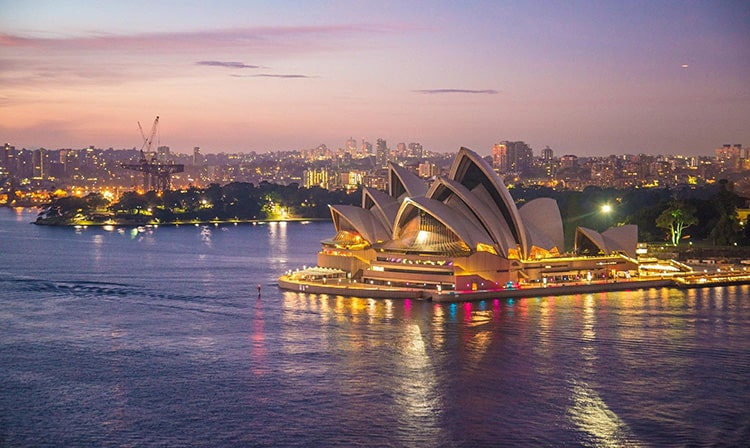 Wide, aerial shot of the Sydney Opera House at dusk.