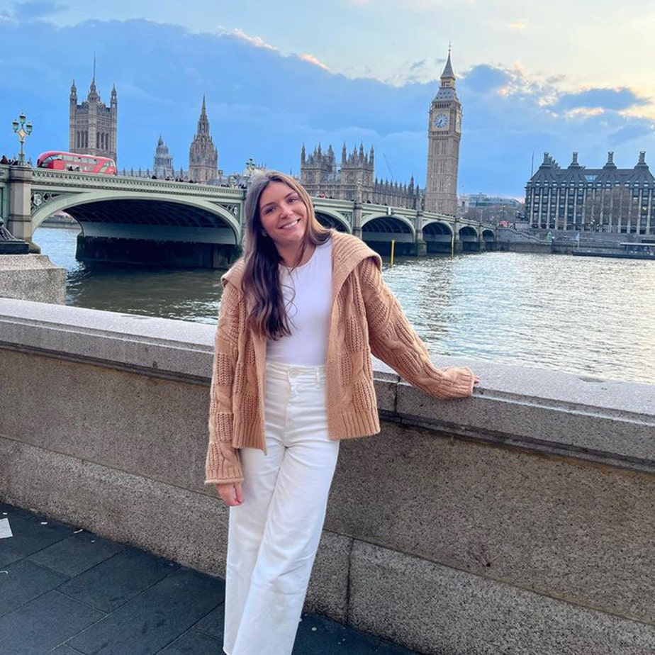 Fairfield student smiling and posing on a sidewalk in London, with the Big Ben clocktower behind.