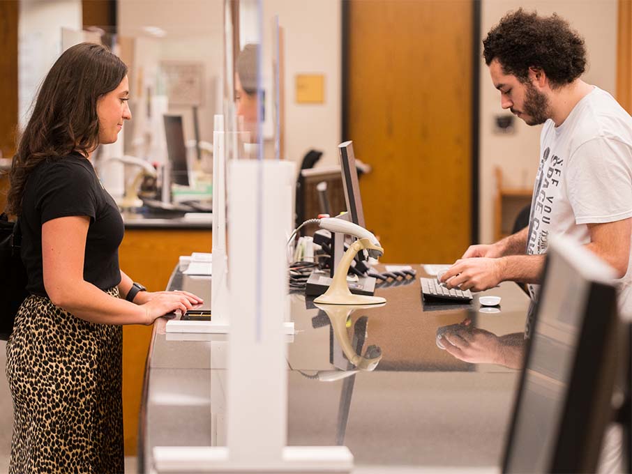 Image of a man and woman stand at a counter, appearing friendly and engaged in a lively discussion.