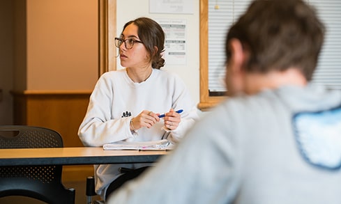 Student looking curiously towards an out-of-shot professor before asking a question.