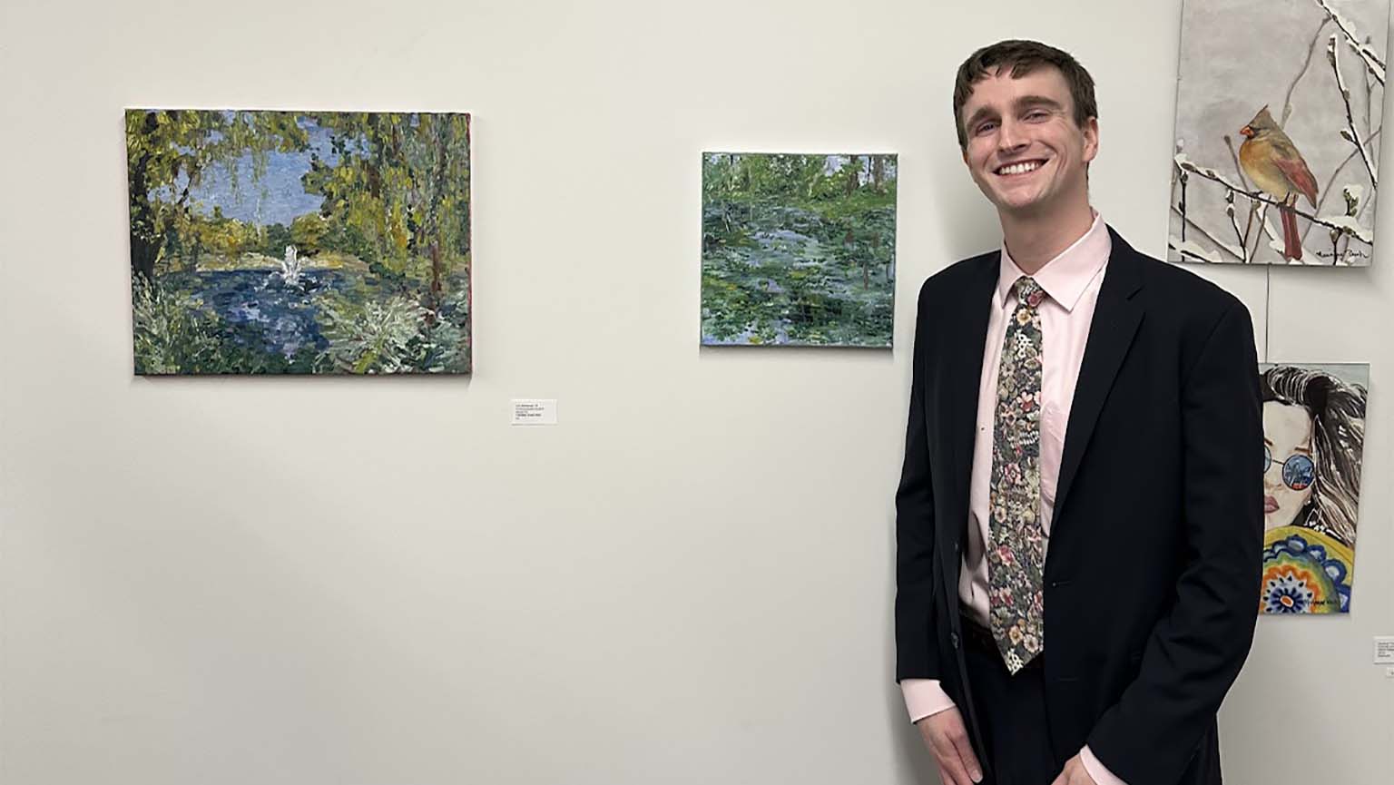 Student standing in front of artwork. 