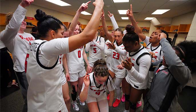 Image of student-athletes celebrating after a Women's Basketball game.