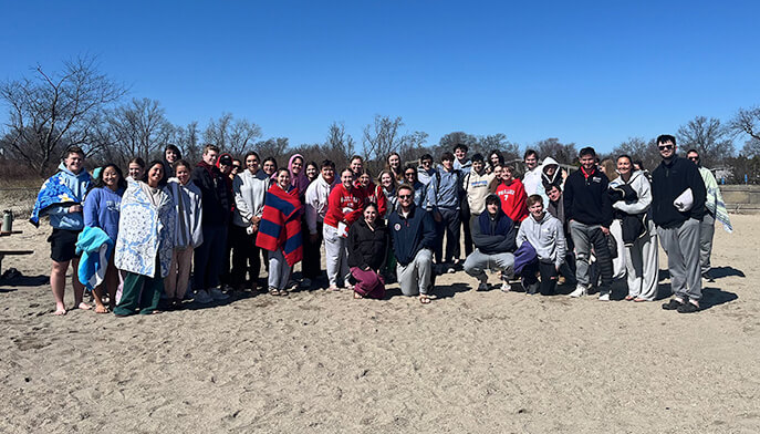 Several individuals gathered on the beach, with a vibrant blue sky overhead, creating a cheerful atmosphere.