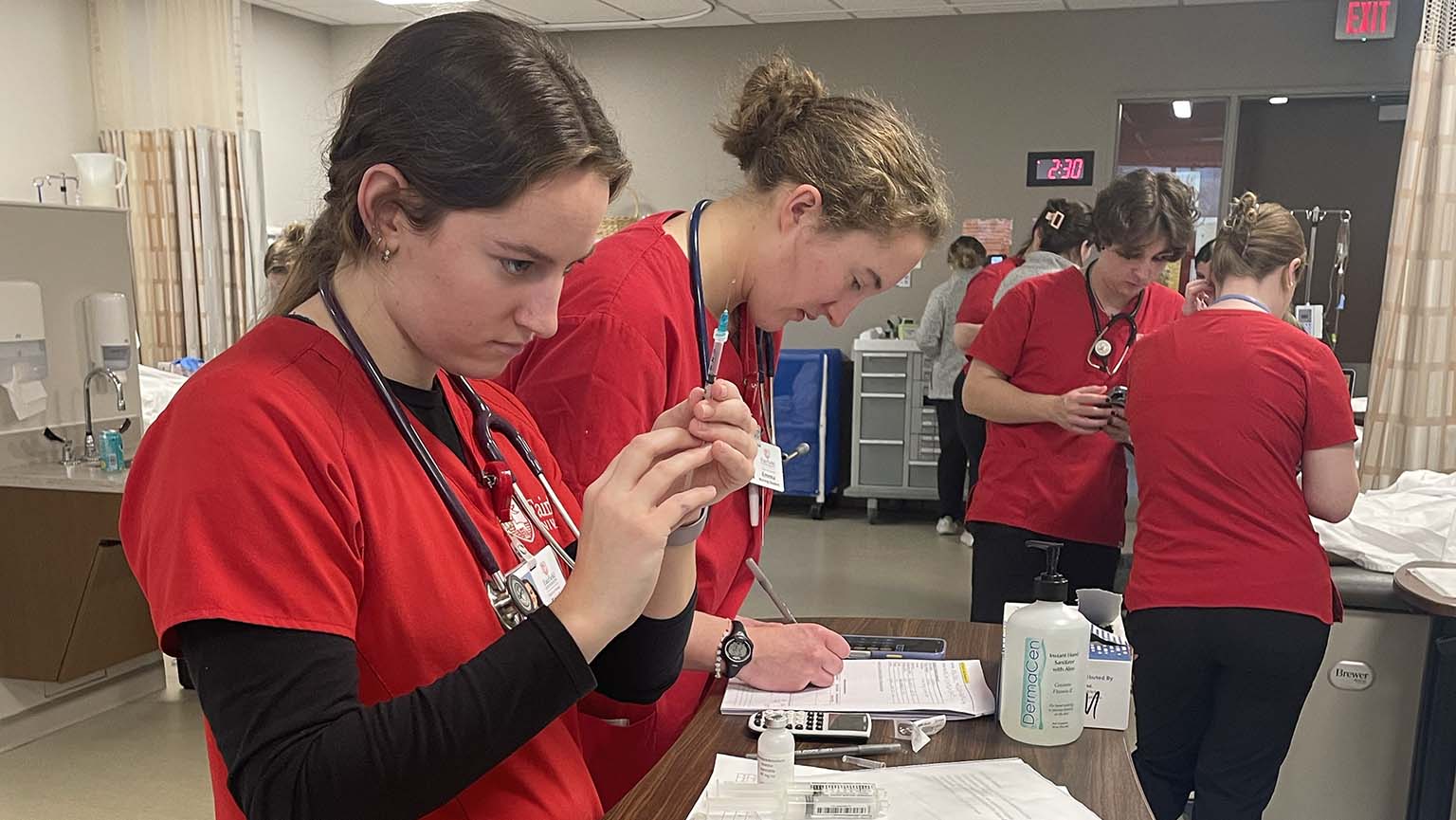 Image of a group of nursing students engaged in hands-on training at a hospital, learning patient care techniques.
