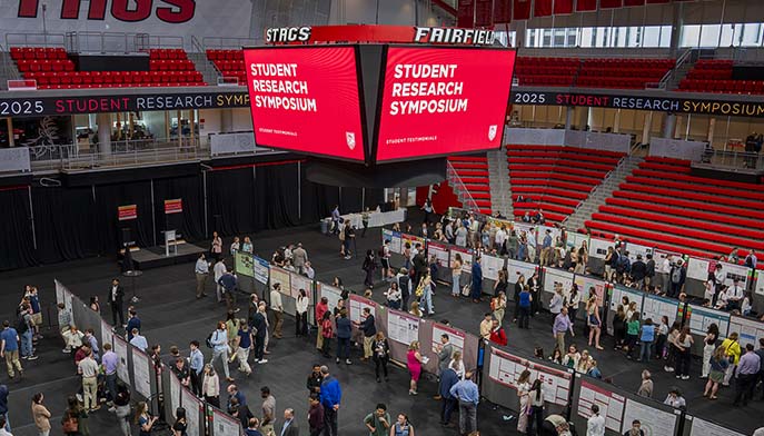 Image of a bustling arena filled with attendees at the Fairfield Student Research Symposium.