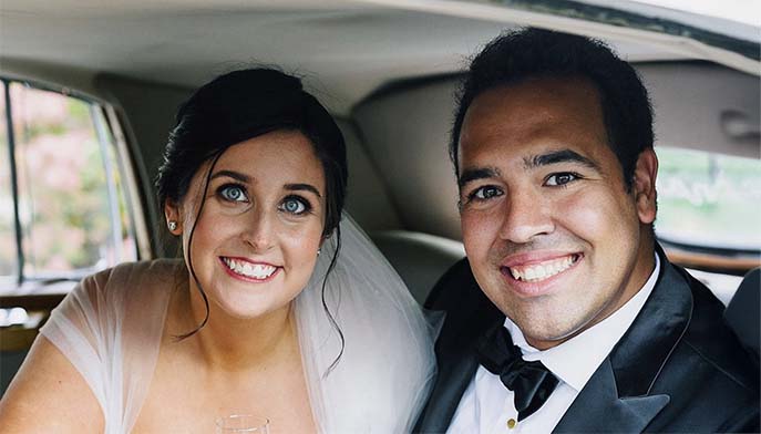 Image of Shannon Gilroy ’14 and Luigi DiMeglio ’14 after their wedding looking outside a car window.