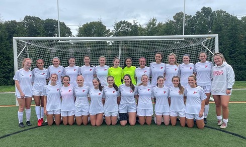 Group shot of Women's Soccer club team outdoors on soccer field.