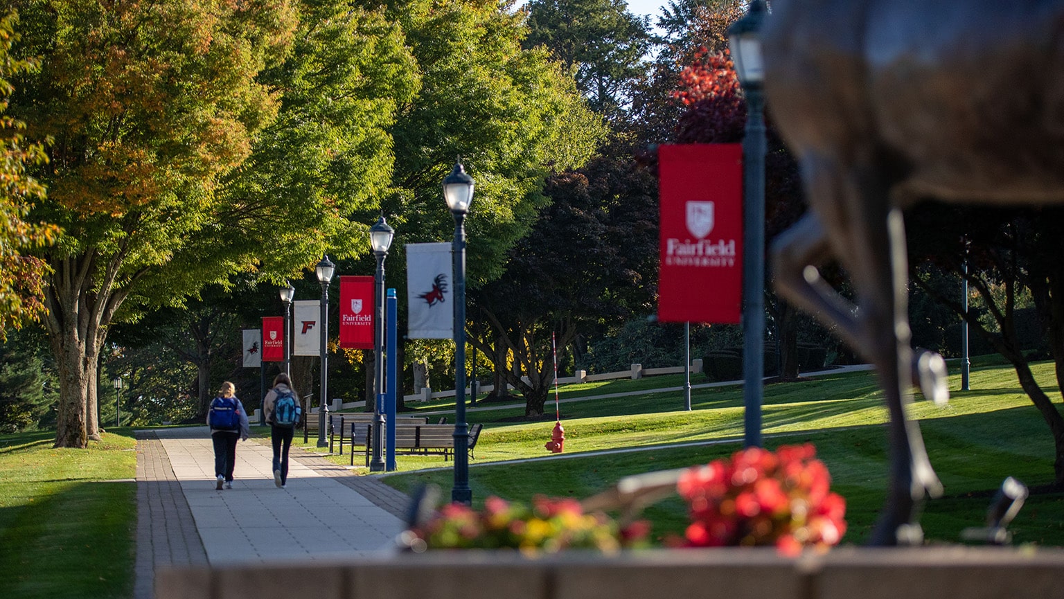 Photo of Fairfield University campus showing walkway and red and white banners.