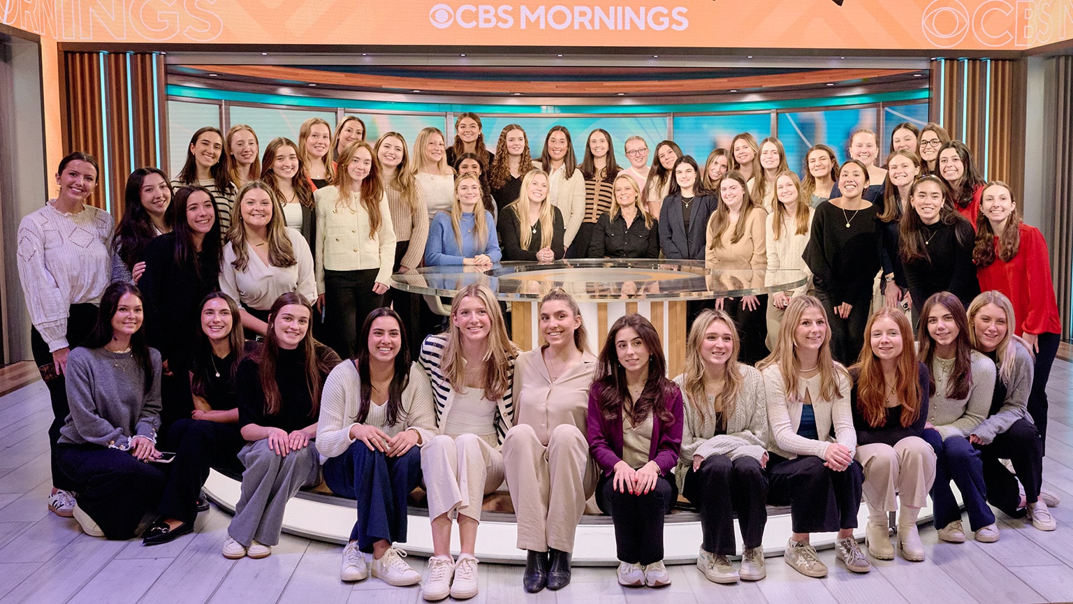 Members of the Women in Business club, totaling nearly 50 women, smiling and posing on the CBS Mornings stage.