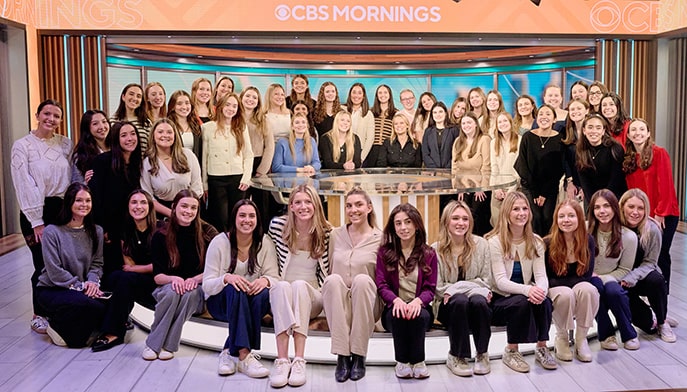 Members of the Women in Business club, totaling nearly 50 women, smiling and posing on the CBS Mornings stage.