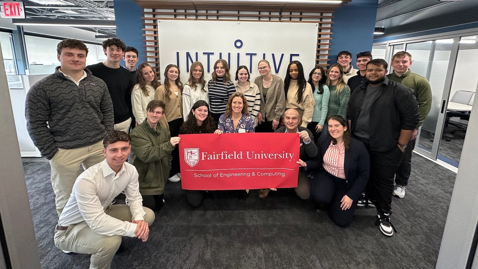 Fairfield students posing in front of the Inuititive Surgical lobby sign.