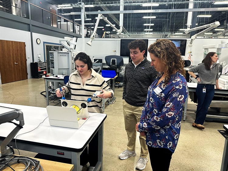 Student performing a microsurgery simulation with precision attachment instruments.